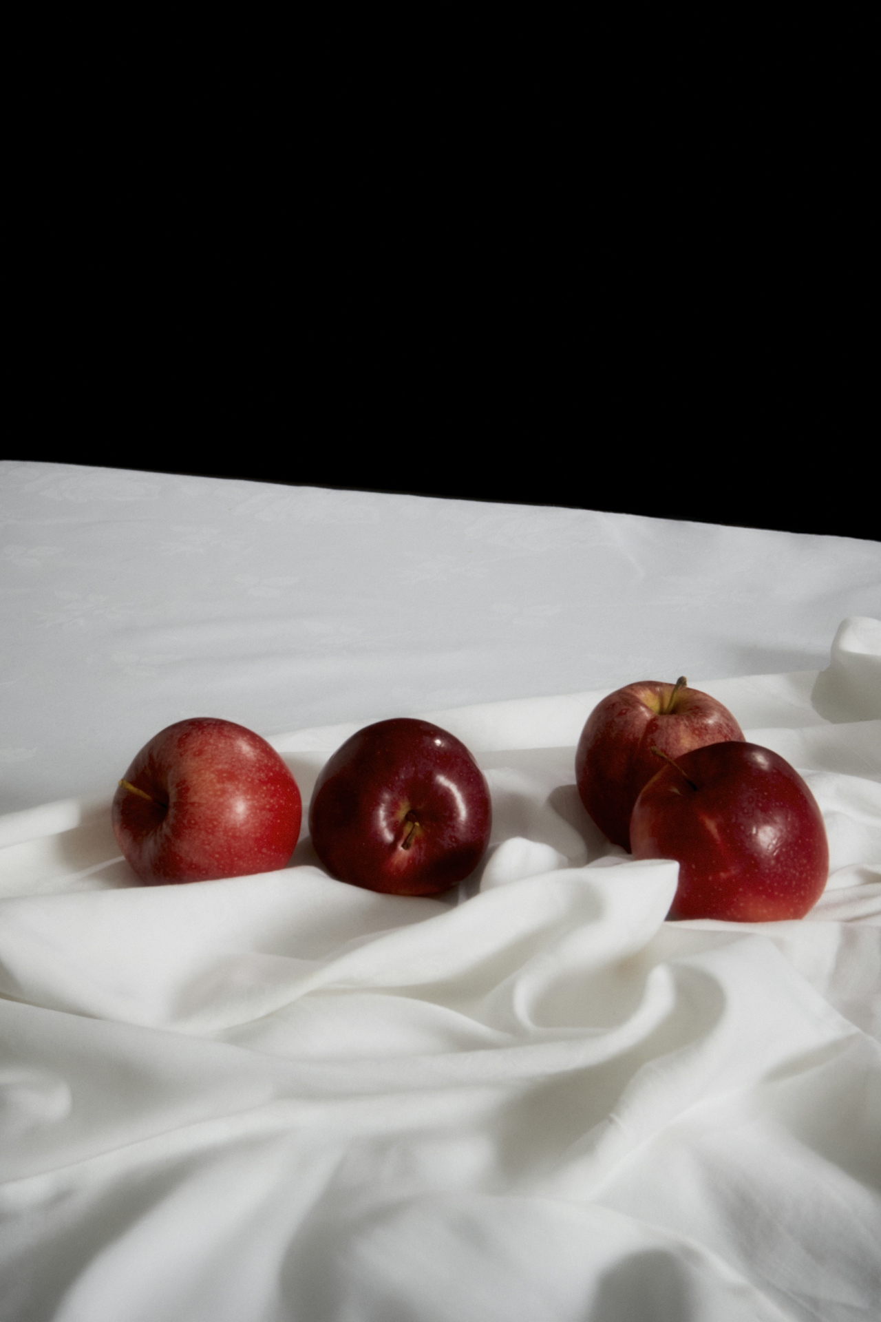 Red apples on white silk